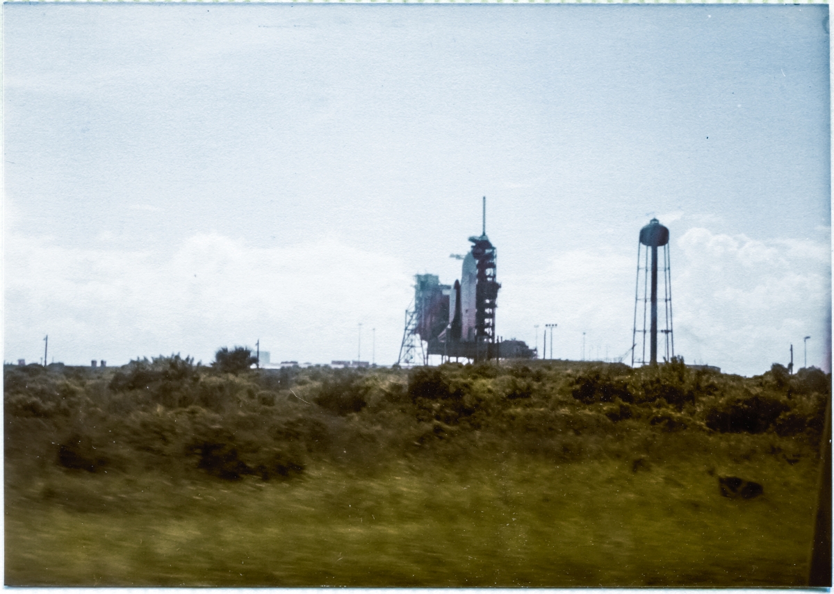 Image 019. The dawning of a new age in spaceflight manifests itself in the form of an incredible gigantic flying machine like no other that had come before it, at any time, at any place. Colombia, sitting in its launch position at the Launch Pad on top of the MLP with the RSS rolled back in its de-mate position, as seen driving along Beach Road past Space Shuttle Launch Complex 39-A, Kennedy Space Center, Florida, on the way to work at Pad 39-B which was still under construction at the time. Photograph by James MacLaren.